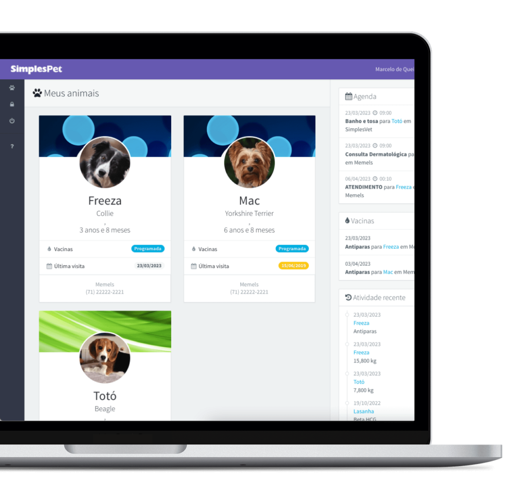 Notebook pela metade com aberto na tela do portal SimplesPet, mostrando a visão de três cachorros
