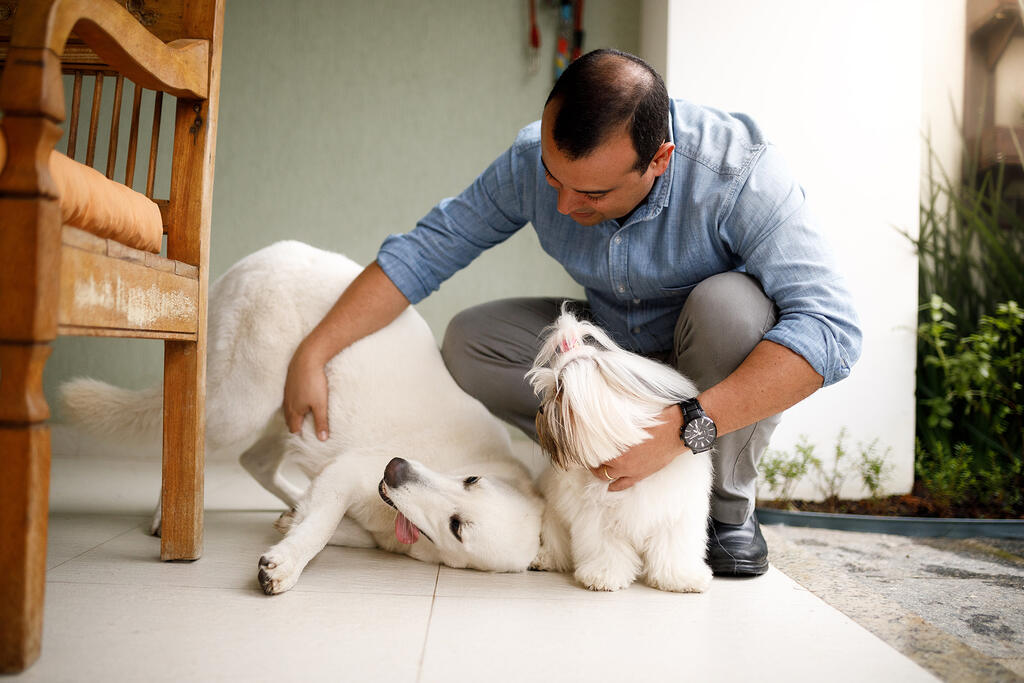 Pessoa e seus pets que podem aproveitar o serviço de banho e tosa a domicílio